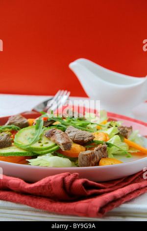 Salat mit Gemüse und Fleisch vom Grill auf einem Teller Stockfoto