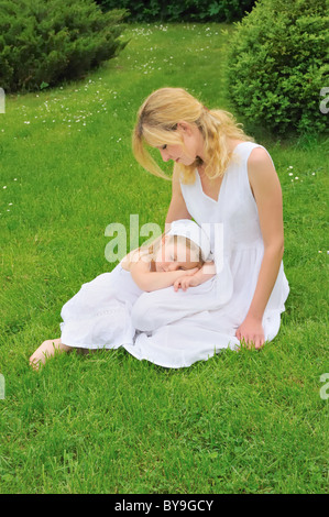 Glückliche junge Mutter und Tochter ruht in Wiese Stockfoto