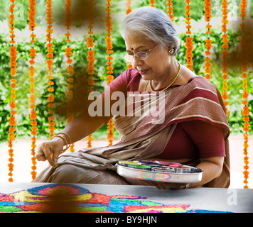 Alte Frau macht ein rangoli Stockfoto