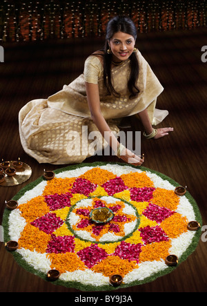 Frau sitzt neben einem rangoli Stockfoto