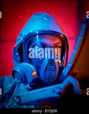 Mit einer Gasmaske Gesicht Mann gekleidet in eine chemische Kriegsführung-Anzug mit einem laptop Stockfoto