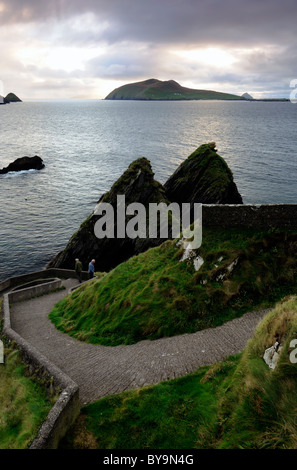 Dunquin Pier Atlantik und Inishtooskert Blasket Inseln Dingle Halbinsel Grafschaft Kerry Irland zwei Männer auf der Suche in Ozean Stockfoto