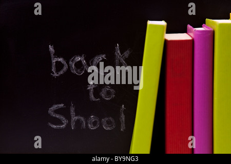 Zurück zu Schule Briefe geschrieben auf einer Tafel mit bunten Büchern (Tiefenschärfe) Stockfoto