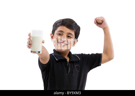 Kleiner Junge seinen Arm zu beugen, halten Sie ein Glas Milch Stockfoto