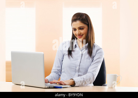 Geschäftsfrau, die auf einem Laptop arbeiten Stockfoto