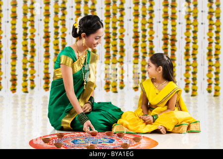 Vermittlung von Diyas auf ein Rangoli Frau Stockfoto