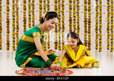 Mutter und Tochter ein Rangoli Diyas Inverkehrbringen Stockfoto