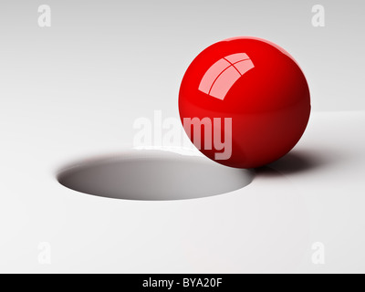 3D rot ball in das Loch fallen in der Nähe Stockfoto