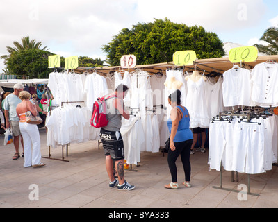 Touristischen Paare untersuchen Frauen weiße Baumwoll-Kleidung zum Verkauf auf dem Wochenmarkt in Teguise Lanzarote Stockfoto