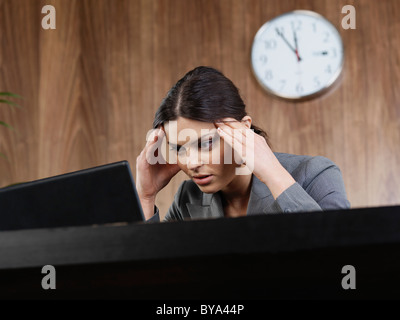 Business Frau Kopf in die Hände im Büro Stockfoto