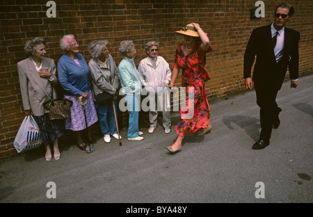 Ankunft für die Royal Ascot-Rennen, finden junge Paar selbst unter die Lupe genommen von Gruppe von älteren Menschen-Beobachter Stockfoto