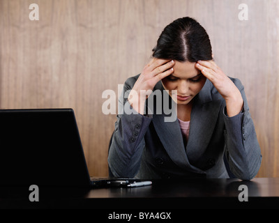 Business Frau Kopf in die Hände im Büro Stockfoto
