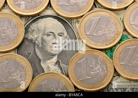 US-Dollar-Banknote unter EURO-Münzen, symbolisches Bild für Fremdwährung Stockfoto