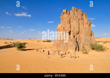 Touristen vor dem Felsen mit der berühmten Rock-Gravur einer weinende Kuh, neolithischen Felsmalereien in der Nähe von Djanet Stockfoto