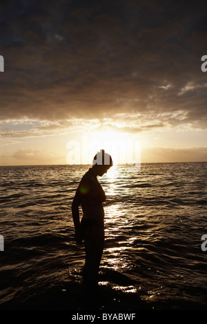 Frau im Meer bei Sonnenuntergang Stockfoto