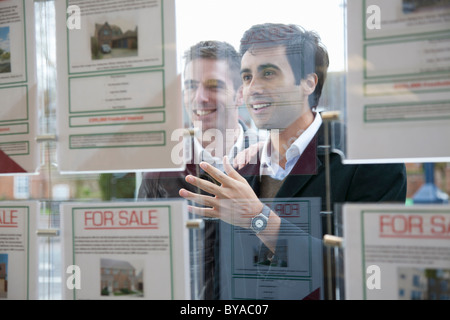 Paar auf der Suche in Immobilienmakler Fenster Stockfoto