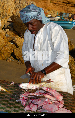 Dunkel-enthäutete Fischhändler Filetieren frischen Fisch auf einem Stand im Freien, Sur, Sultanat Oman, Naher Osten Stockfoto