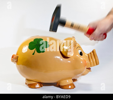 Überfall auf das Sparschwein mit hammer Stockfoto