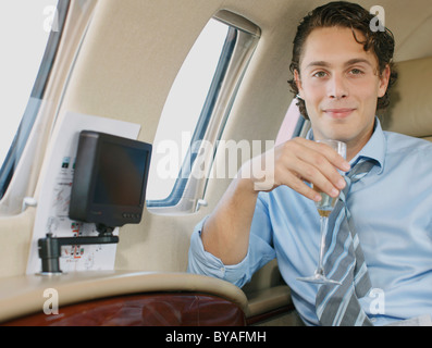Lächelnde Geschäftsmann im Privatjet Stockfoto