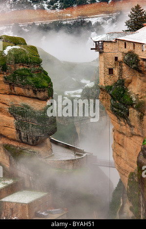 Die hölzerne Brücke verbindet das Kloster Varlaam mit dem Rest von Meteora, umgeben von Nebel. Trikala, Thessalien, Griechenland Stockfoto