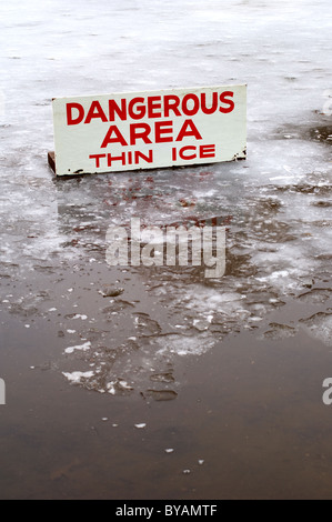 Ein Teich abgedeckt in einer dünnen Schicht aus Eis mit einigen open Water und ein Zeichen der Gefahr bedeutet. Stockfoto