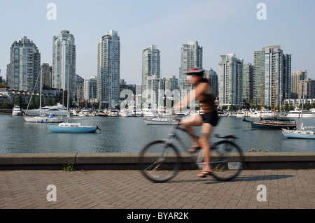 Ein Radfahrer vorbei an der Kaimauer des False Creek in Vancouver, Kanada Stockfoto