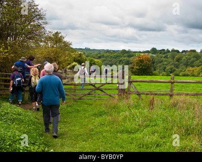 Gruppe von Wanderern, Klettern über einen Stil, Stroud, Gloucestershire, Cotswolds, UK Stockfoto