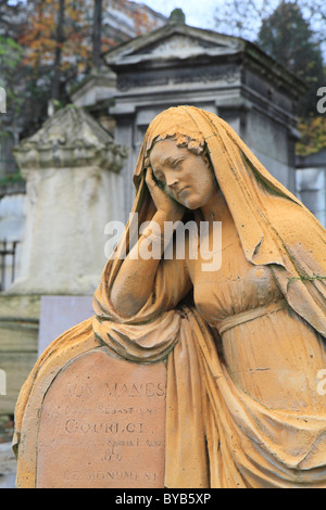 Grab mit einer trauernden Frau ein Kopftuch mit Arm ruht auf einem Grabstein, Friedhof Père Lachaise, Paris, Frankreich Stockfoto