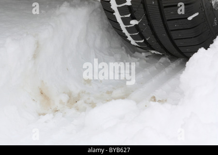 Winterreifen auf einer verschneiten Straße Stockfoto