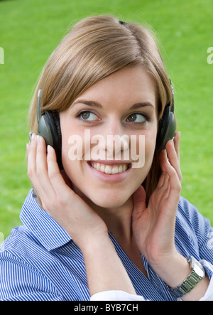 Junge Frau trägt Kopfhörer Stockfoto
