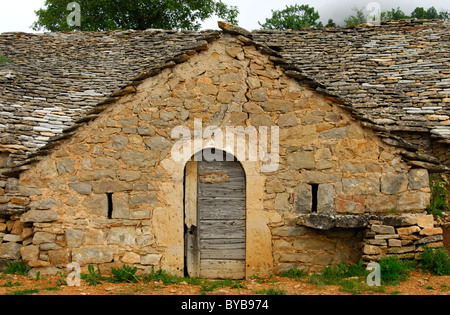 Holztür ein halb verlassene Höhlenwohnungen Wine cellar mit Naturstein Dach in Entre-Deux-Monts in Rivière-Sur-Tarn, Aveyron Stockfoto