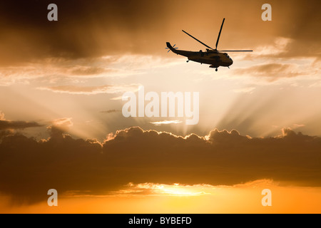 Jacobs Leitern verursacht durch die untergehende Sonne und ein Hubschrauber. Stockfoto