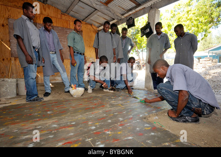 Schulungen bei der Verlegung von Fliesen für Jugendliche aus den Slums Cite Soleil Salesianer Projekt Lakay oder The House Stockfoto