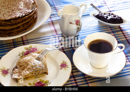 Ein Stapel von isländische Pfannkuchen, Kaffee, Blaubeeren Marmelade und einem Pfannkuchen gefaltet zweimal mit Sahne und Blaubeeren Marmelade. Stockfoto
