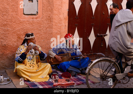 Paar gnawa Straßenmusikanten spielen und hajhuj krakeb in Marrakesch im Gespräch mit Passanten Marokko Stockfoto