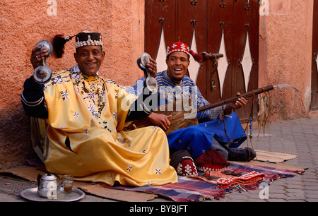 Glückliches Paar gnawa Straßenmusikanten spielen und hajhuj krakeb und Gesang in Marrakesch mit schwingenden tarboosh Quasten Marokko Stockfoto