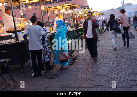 Schnecke Snack Stand Anbieter anrufen von schönen Frauen, die zu Fuß in Djemaa el Fna Platz Marrakesch Stockfoto