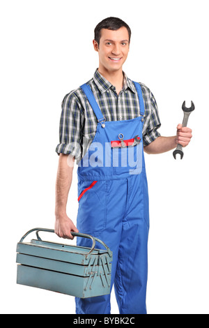 Ein Mechaniker in blau insgesamt hält eine Toolbox und Schraubenschlüssel Stockfoto
