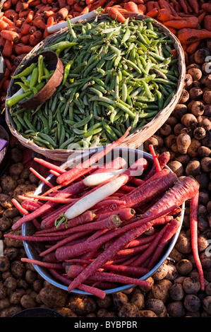 Korb mit Erbsen und langen roten Karotten auf einer indischen Gemüsemarkt. Andhra Pradesh, Indien. Stockfoto