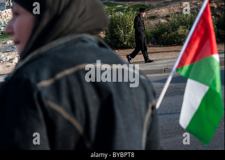 Ein orthodoxer Jude vorbeigeht wie ein palästinensischer Aktivist Proteste jüdischer Siedlungen in Ost-Jerusalem. Stockfoto