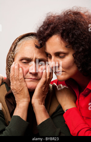 Studioaufnahme einer jungen Frau, die ihre alte Mutter tröstet Stockfoto