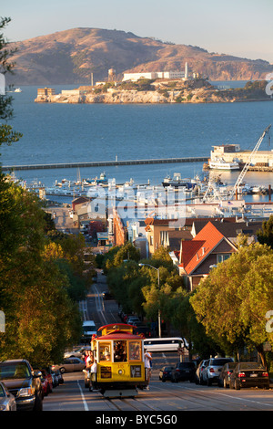 Reiten die historische Seilbahn Powell-Hyde, Alcatraz im Hintergrund, San Francisco, CA Stockfoto