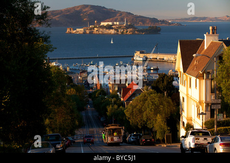 Reiten die historische Seilbahn Powell-Hyde, Alcatraz im Hintergrund, San Francisco, CA Stockfoto