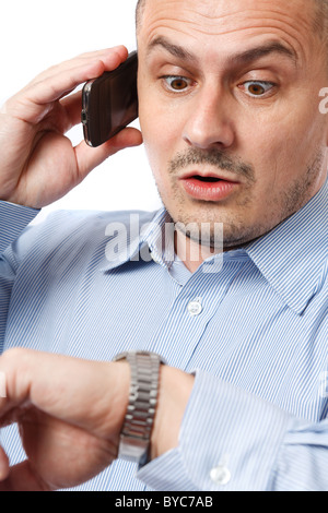 Junger Geschäftsmann besorgt Blick auf seine Armbanduhr Stockfoto