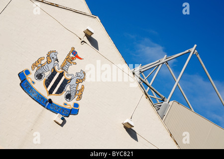 Newcastle United-Logo auf Pub Wand mit St. James Park (Newcastles Boden) im Hintergrund Stockfoto