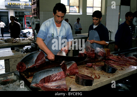 Fischhändler hacken frisch gefangen Thunfisch in Steaks auf einem Marmortisch in Funchals Mercado Dos Lavradores auf Madeira Stockfoto