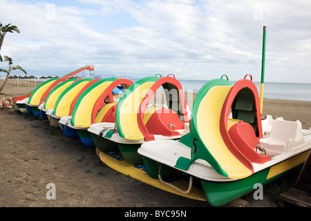 Reihe von farbigen Tretboote mit Folien am Strand in Torremolinos, Costa Del Sol, Spanien. Stockfoto