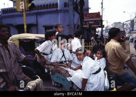 Schulmädchen in weißen Uniformen Reiten eine Velo-Rikscha zur Schule in Alt-Delhi, Indien. Stockfoto