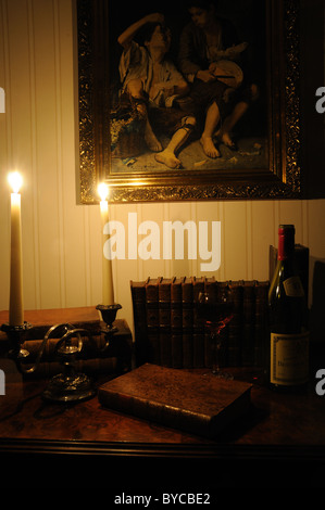 Antiquarische Bücher und Wein mit Kerzenlicht beleuchtet Stockfoto