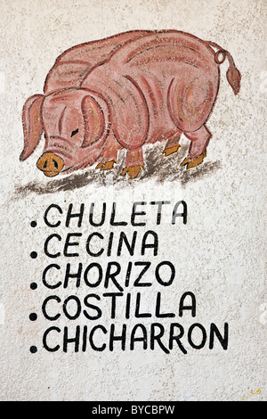 Whimsical Hand gemalte Zeichen Malerei an der Wand der Mexikanischen Metzgerei, pink Curly tailed Schwein & Werbung Schweinefleisch mit street art Stockfoto